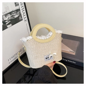Detailed macro view of straw woven bag featuring white lace trim and satin bow decoration