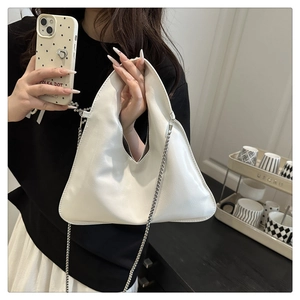 Detailed shot of white triangular PU leather handbag with elegant silver chain strap