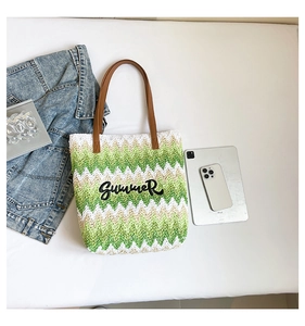 Flat lay of a woven tote bag with wave patterns and Summer embroidery on a white background