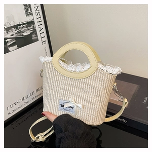 Détail du sac seau en paille avec élégante bordure en dentelle blanche et nœud