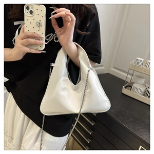 Detailed view of white triangular chain bag in polished PU leather for elegant styling