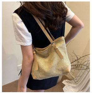 Detail of summer straw tote bag with leather shoulder strap and adjustable metal buckle