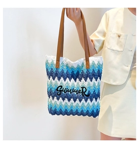 Detail of blue and white wave straw tote bag with Summer embroidery and leather straps