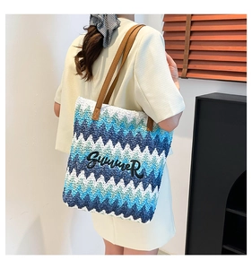 Detail of woven tote bag with wave pattern, Summer embroidery and brown leather straps