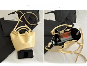 Detail of light yellow mini bucket bag showing interior space for phone and lipstick