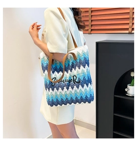 Detail of woven beach tote with blue zigzag pattern and Summer embroidery on the front