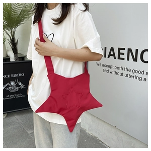 Detail of red star-shaped crossbody canvas bag with matching strap and stitching details