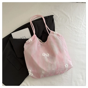 Detail of pink tie-dye tote bag with 3D floral embroidery and round cord handles