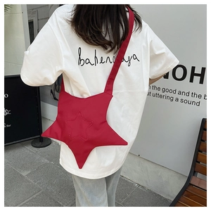 Vue détaillée du dos d'un sac bandoulière en nylon rouge en forme d'étoile porté par un mannequin