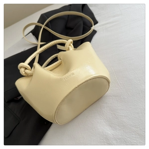Détail d'un sac seau crème avec gravure Lucky Bag Fashion et poignée nouée