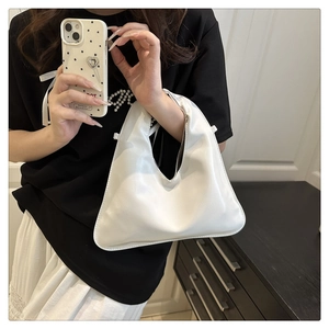 Close-up of a white geometric PU leather handbag with a minimalist top handle and strap