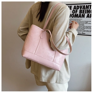 Detail of pink faux leather tote bag featuring embossed cartoon motifs and versatile straps