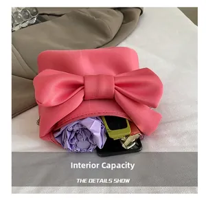 Capacité interne du sac rose avec nœud contenant parapluie, lunettes et téléphone