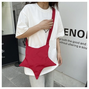 Close-up of a red star-shaped canvas crossbody bag featuring wide shoulder straps and stitching