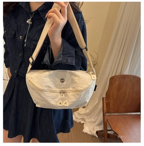 Detail of adjustable strap and lightweight nylon fabric on beige crossbody bag