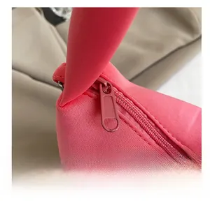 Gros plan détaillé sur la fermeture éclair en métal rose d'un sac à bandoulière en tissu rose