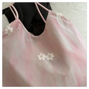 Detail of floral lace embroidery on pink gradient fabric with delicate thin straps