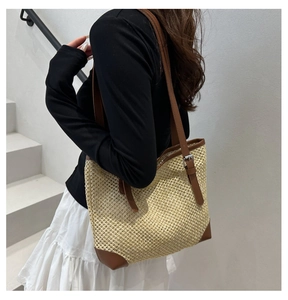 Adjustable brown leather strap detail on a beige woven straw summer tote bag for women