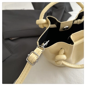 Détail du sac seau crème montrant le fermoir magnétique et la doublure en tissu noir