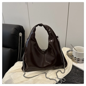 Close-up of dark brown hobo bag with vintage oil leather texture and knot handle detail
