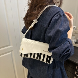Chic white piano key shoulder bag with gold musical note print and wave flap