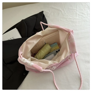 Detail of floral embroidery on pink organza tote bag with interior storage view