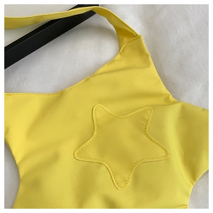 Gros plan détaillé du sac bandoulière jaune en forme d'étoile avec coutures appliquées