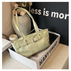 Detail of light green baguette bag with shiny leather texture and silver buckle