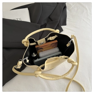 Interior view of pleated bucket bag showing capacity for phone and notebook