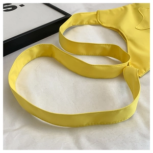 Détail de la large bandoulière jaune et de l'étoile sur le sac à bandoulière en nylon