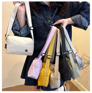 Detailed close-up showing multiple colors and wide adjustable straps of nylon crossbody bags