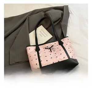 Detailed close-up of a pink tote bag featuring black bow prints and a ribbon detail