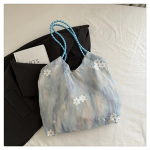 Detail of floral embroidery and tie-dye fabric on a bohemian shoulder tote bag