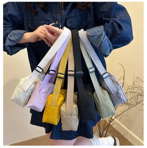 Close-up of nylon crossbody bags in seven colors with adjustable straps and buckles