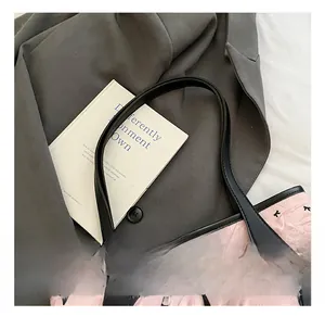 Close-up of pink tote bag with black bow prints and durable faux leather handles