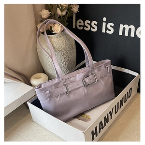 Detail of light purple baguette bag with glossy leather and silver buckles in elegant decor