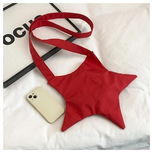 Macro detail of red star-shaped canvas crossbody bag shown next to a smartphone for size
