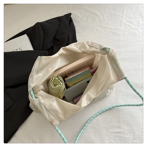 Interior view of embroidered tote bag filled with umbrella, books, and smartphone