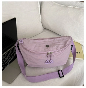Detailed macro view of lavender nylon crossbody bag with dual zippers and branded label