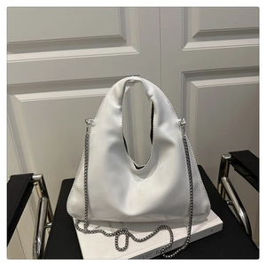 Macro shot of white geometric PU leather handbag featuring silver metal chain and handle