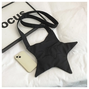Detailed view of black star-shaped crossbody bag with smartphone for size reference