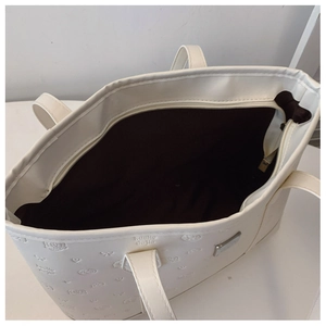 Vue de dessus du sac cabas blanc avec fermeture éclair, doublure brune et motifs en relief