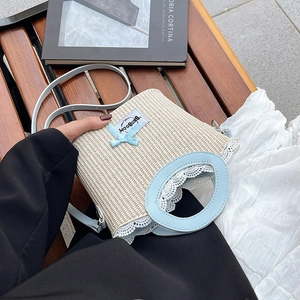 Stro emmer tas met blauwe leren riemen, fijne kant details en een strik decoratie