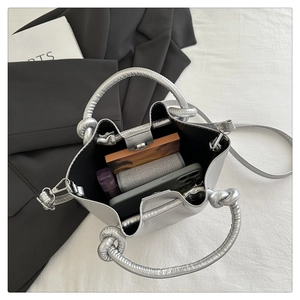 Interior view of silver metallic bucket bag showing capacity for phone and wallet
