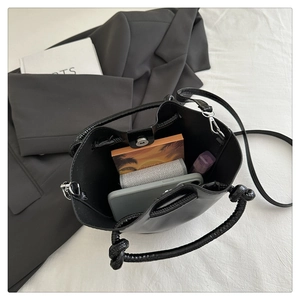 Top view of black bucket bag interior showing large capacity for phone and cosmetics
