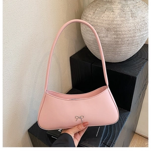 Detail of pink baguette bag with silver bow buckle on modern geometric display