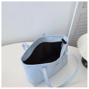 Detailed interior of light blue tote bag showing embossed patterns and large capacity