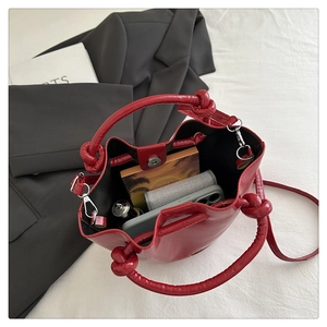 Internal view of red bucket bag showing spacious storage for phone and cosmetics