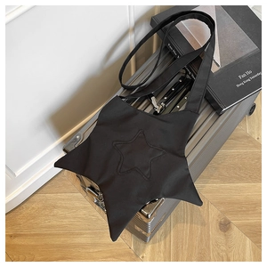 Detailed view of black star-shaped canvas crossbody bag with decorative stitching