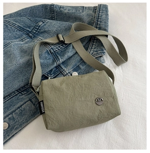 Detail of light green nylon crossbody bag with metal logo and fanyissa woven label